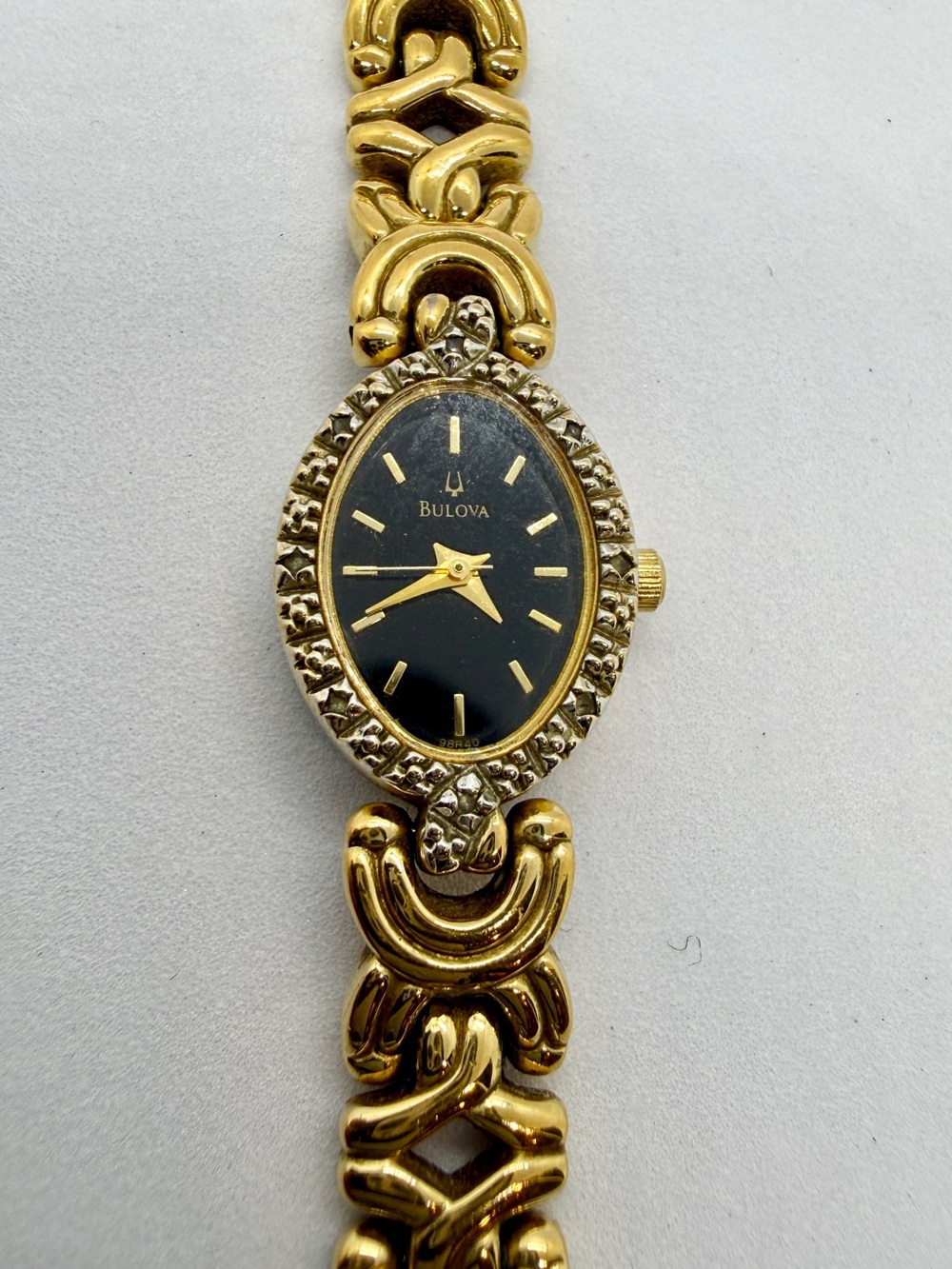 Bulova Gold Tone Dainty Oval Wristwatch Black Dial Textured Bezel Link Bracelet